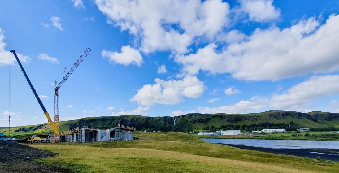 Tveir kranar við gestastofuna og ef vel er gáð má sjá byggingarkrana við læknisbústaðinn upp við fja…