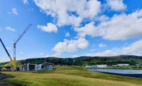 Tveir kranar við gestastofuna og ef vel er gáð má sjá byggingarkrana við læknisbústaðinn upp við fja…